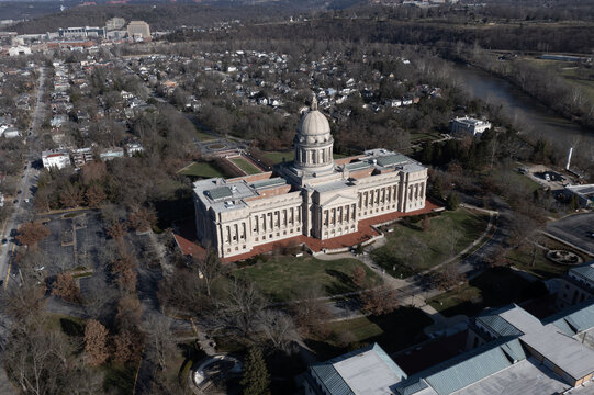 Aerial view of the Kentucky State Capitol building surrounded by trees and urban landscape in Frankfort, Kentucky, United States.