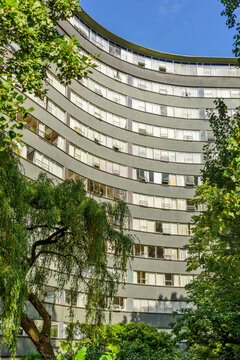 Curved Multi-Story Residential Apartment Building Framed by Lush Green Trees