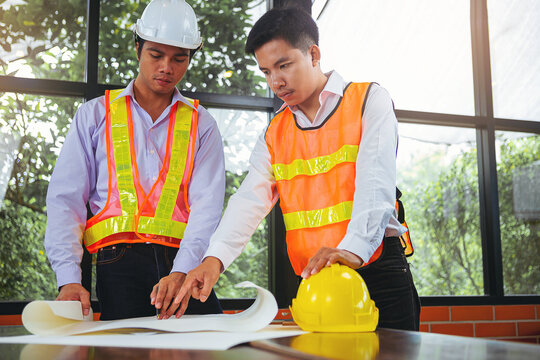 Structural engineer and architect and foreman worker with blueprints discuss, plan working for the building construction site office. Construction collaboration concept