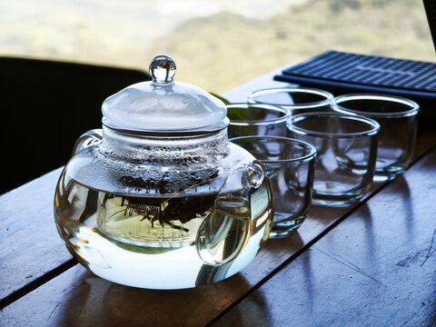 Transparent Teapot and Empty Glasses on a Rustic Wood Table