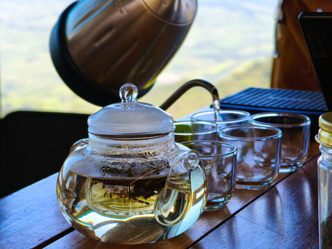 Pouring Hot Water Into Glass Teapot With Loose Tea Leaves