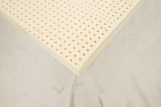 100% natural latex foam sheet layer with pinholes isolated on black background, organic raw material for luxury mattress topper manufacturing