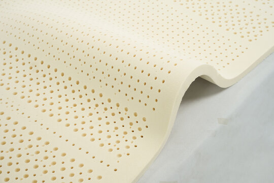 100% natural latex foam sheet layer with pinholes isolated on black background, organic raw material for luxury mattress topper manufacturing