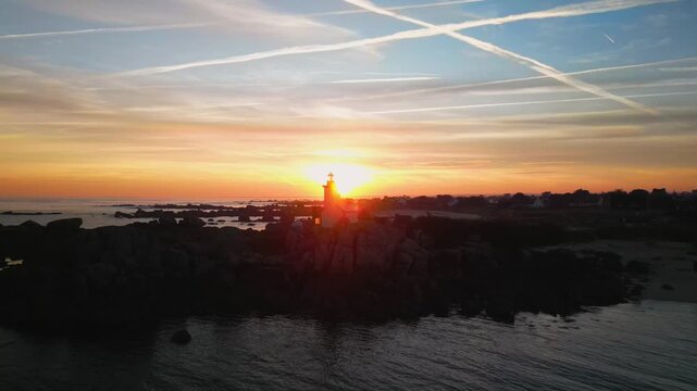 Aerial view sunrise over lighthouse on a rocky coastline. Normandy, France. Travel and tourism footage