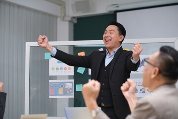 Fototapeta premium Asian businessman presenting corporate strategy during boardroom meeting.Male executive explaining charts and graphs to colleague in modern office. Asian manager leading a business presentation.