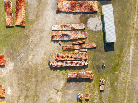 Aerial view of Kleinvlei showing rows of stacked orange crates arranged in an open field near a metal shed in Cape Town, Western Cape, South Africa.