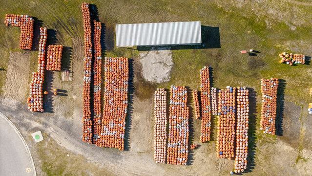 Aerial view of rows of orange gas cylinders stored in an open lot near a building in Kleinvlei, Cape Town, Western Cape, South Africa.