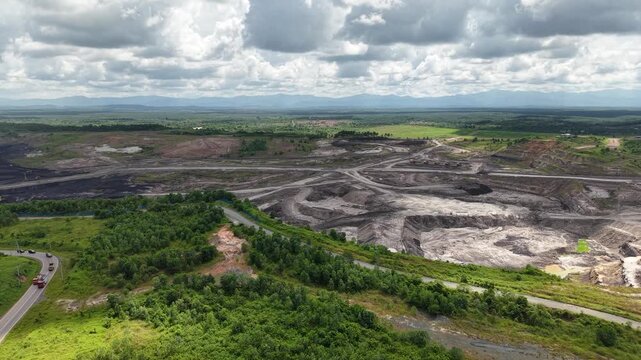 Aerial view of a coal mining site right next to a highway with deep excavations resulting from mining operations