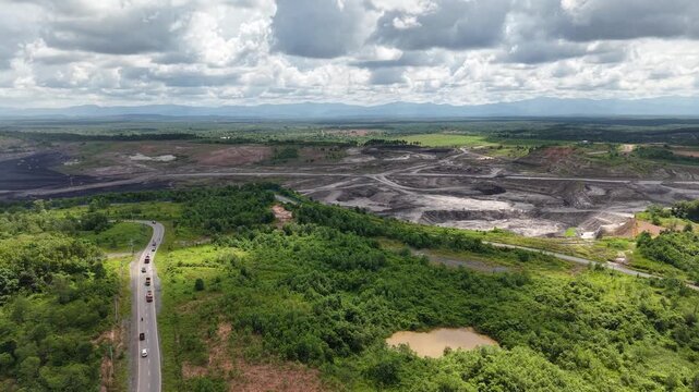 Aerial view of a coal mining site right next to a highway with deep excavations resulting from mining operations
