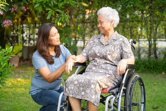 Caregiver help and care Asian senior woman patient sitting on wheelchair at nursing hospital ward, healthy strong medical.