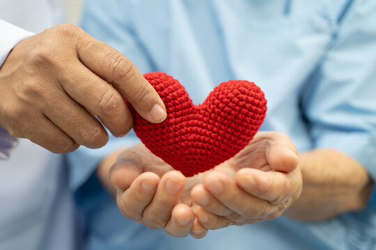 Doctor holding a red heart in hospital, healthy strong medical concept.