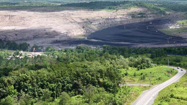 Aerial view of a coal mining site right next to a highway with deep excavations resulting from mining operations