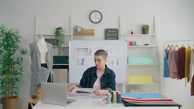 Caucasian young woman working as fashion designer in tailor studio.