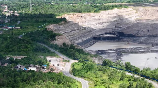 Aerial view of a coal mining site right next to a highway with deep excavations resulting from mining operations