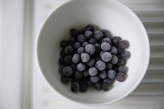 frozen blueberries in white bowl