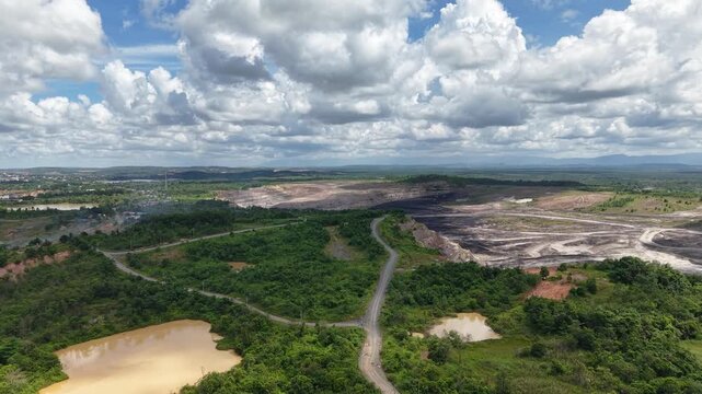 Aerial view of a coal mining site right next to a highway with deep excavations resulting from mining operations