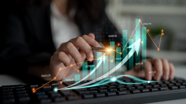 A business professional uses a keyboard while examining financial data. The image showcases digital graphs and charts symbolizing growth and market analysis trends. Scalp
