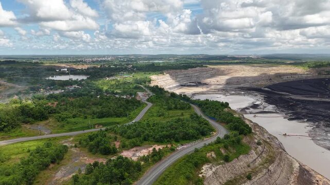 Aerial view of a coal mining site right next to a highway with deep excavations resulting from mining operations