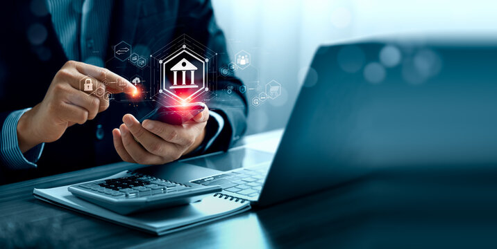 Digital banking concept with business professional using smartphone beside laptop and calculator showing virtual bank interface online payment security transfer and fintech service technology