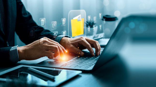 Digital file management concept with business professional holding virtual folder interface over laptop showing cloud document network data storage and workflow organization technology
