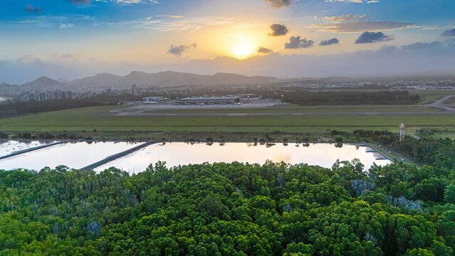 Sunset over Vit&oacute;ria airport landscape with green fields and mountains, Brazil
