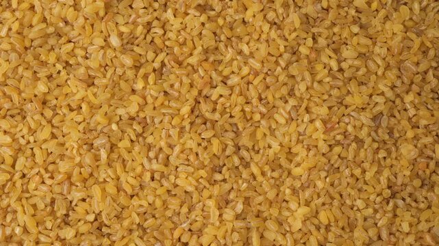 Raw bulgur wheat groats background texture