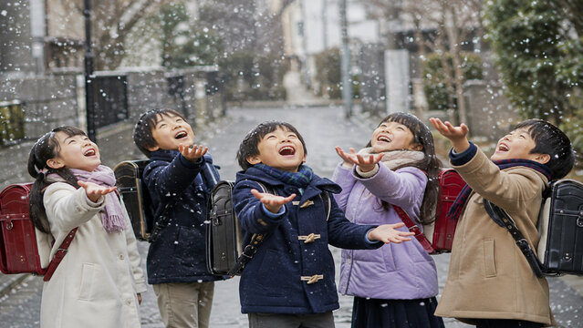 Japanese Elementary School Children Excited by the First Snow on Their Way Home