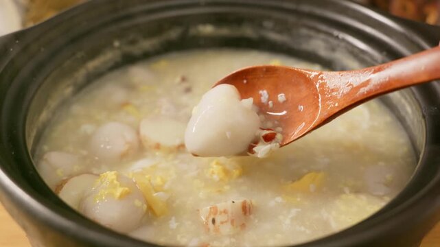 Close-up shot of congee simmered with Chinese yam, egg, lychee and rice.