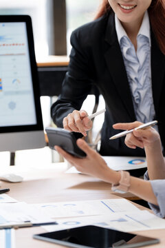 Asian Business Women Working Together with Calculator and Computer in Office