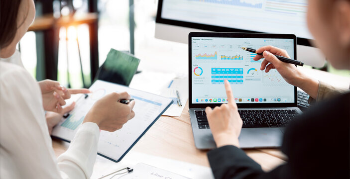 Asian Business Women Analyzing Financial Data and Dashboard on Laptop in Office