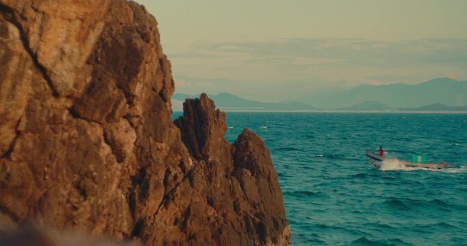 Dramatic rugged rocky coastal cliff formation rising above the calm ocean waters. Scenic marine landscape highlighting natural geology and erosion