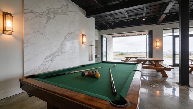 Modern Luxury Billiard Room Interior With Green Pool Table Marble Feature Wall Warm Lighting and Outdoor Seating Area
