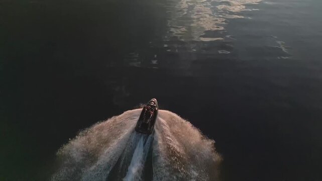 Lake Paranoa, South Lake, Brasilia, Federal District, Brazil, revealing a wakeboard boat carving across calm water, symmetrical wake trails, golden sunset reflections and smooth surface conditions
