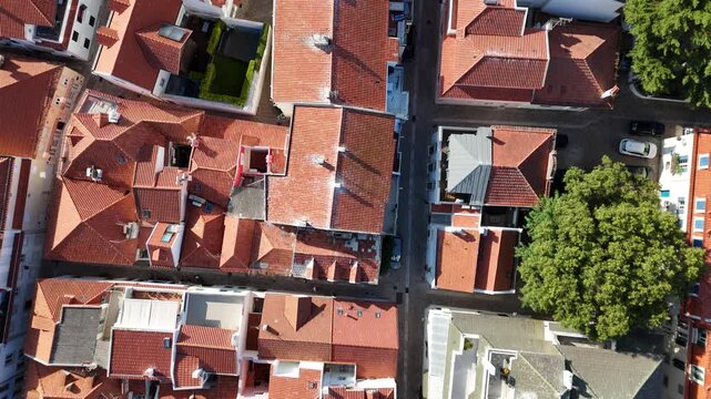 Aerial view of red-tiled rooftops and narrow streets in the historic urban center of Cascais, Lisboa, Portugal.