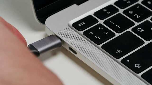USB Charging Connection Between Laptop and Mobile Device on Clean Workspace