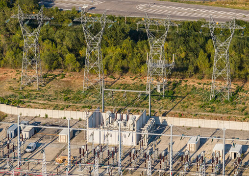 Aerial view of high voltage transmission towers and an electrical substation with transformers and grid infrastructure in Saulce-sur-Rhone, Auvergne-Rhone-Alpes, France.