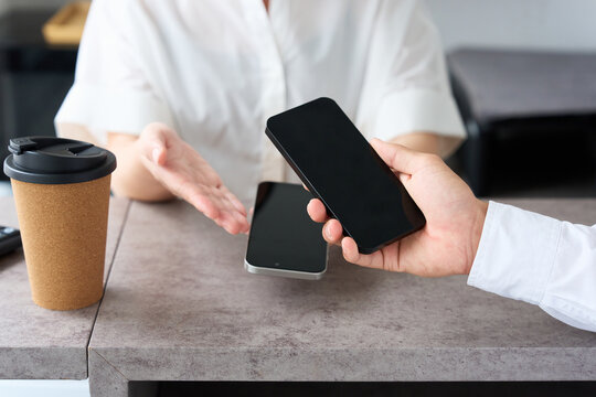 Young Japanese Woman Making Cashless Payment with Smartphone at Cafe Counter