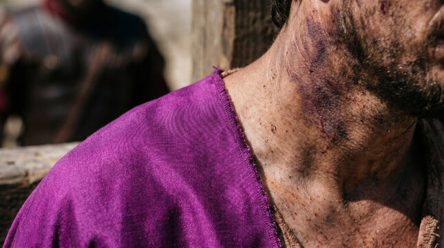 King Herod Antipas mocking Jesus by draping a lavish, elegant royal robe over his shoulders before sending him back to Pilate.