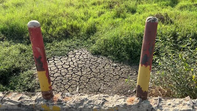 Cracked Landscape Reveals Severe Water Shortage and Environmental Stress. Severe Drought During Prolonged Dry Season With Cracked Earth and Withered Grass
