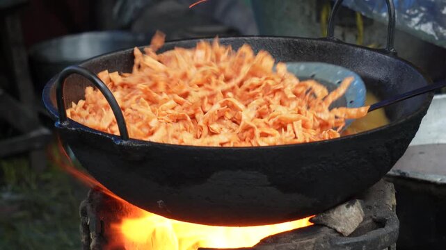 Namkeen snacks deep frying in a hot iron kadai