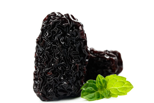 Large Dried Black Jujube Fruits with Fresh Mint Leaves Isolated on White Background