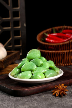 Artisanal Green Pickled Vegetables on Rustic Wooden Tray with Traditional Jadeite Dishware and Spices