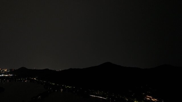 Night view of city lights and rolling mountains along the river