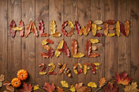 Halloween Sale 22 Percent Off with Autumn Leaves on Wooden Background
