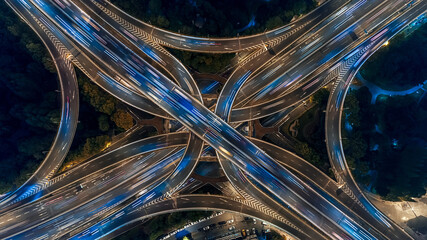 Aerial Night View of Busy Multi-Level Highway Interchange with Light Trails © MaiVan
