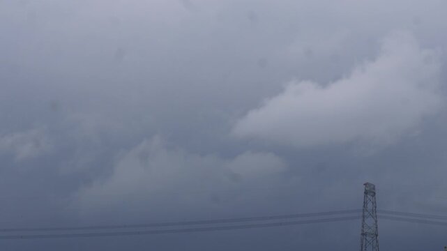 Dramatic storm clouds gathering over utility pole
