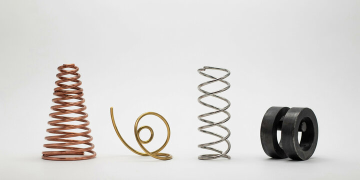 Assorted metal springs and coiled wire components arranged on white background