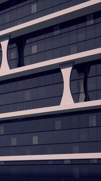 A tall building with unique architectural lines stands in an urban area. Glass windows reflect the light during the evening. The structure shows modern design features and clear lines.