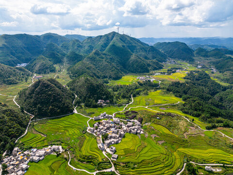 Aerial view of winding roads through green mountain valley and terraced fields