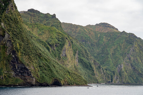 Rugged, mountainous Gough Island, with sheer cliffs rising above the shore, in the South Atlantic Ocean